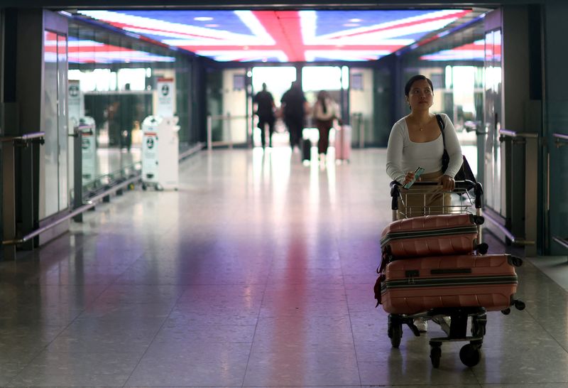 FILE PHOTO: Passengers wait at Heathrow Terminal 5 airport