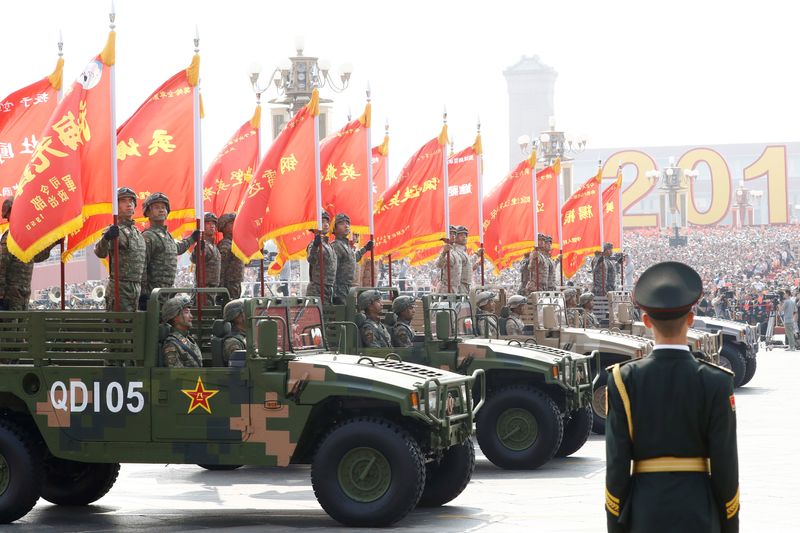FILE PHOTO: Troops in military vehicles take part in the military parade marking the 70th founding anniversary of People's Republic of China, on its National Day in Beijing