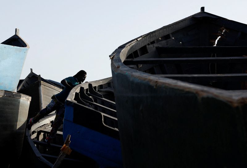 Mohamed Fane is seen in a cemetery of abandoned wooden boats in Arinaga