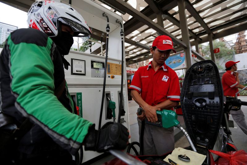 FILE PHOTO: An employee at a Total fuel station fills up a motorcycle in south Jakarta