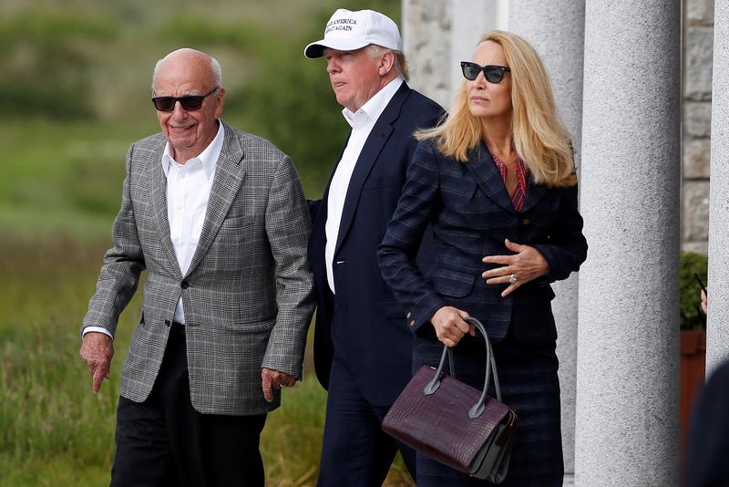 FILE PHOTO: Republican presidential candidate Donald Trump speaks to media mogul Rupert Murdoch and at his wife, former model Jerry Hall as they walk out of the Trump International Golf Links in Aberdeen