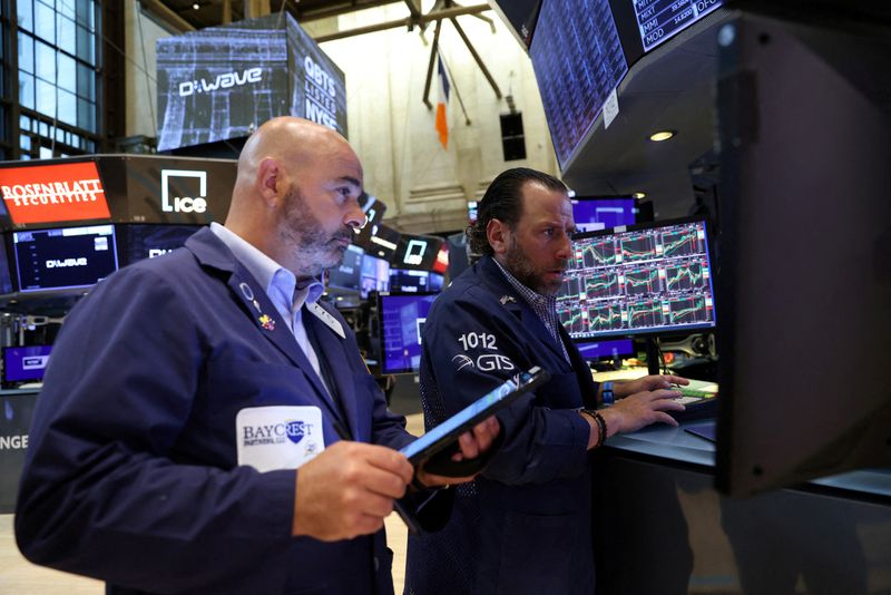 FILE PHOTO: Traders work on the trading floor at the New York Stock Exchange (NYSE) in Manhattan, New York City