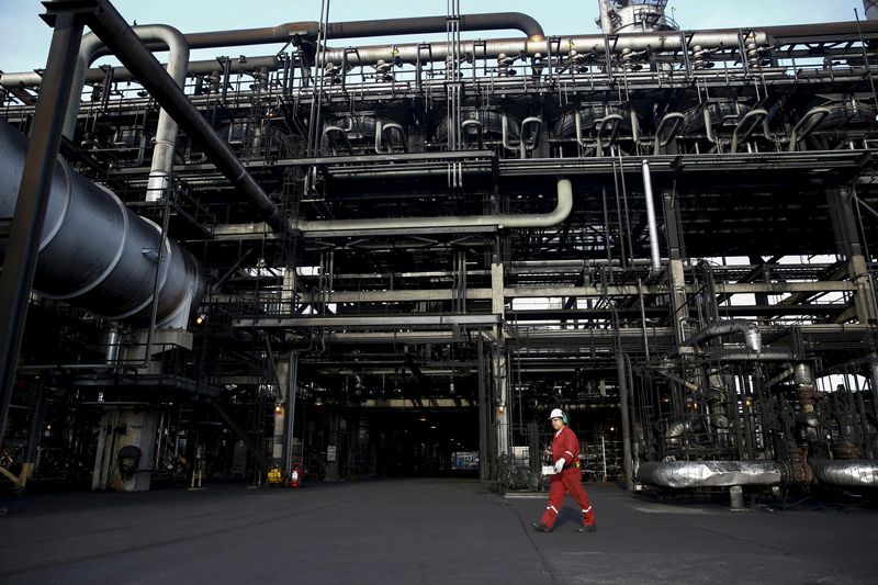 FILE PHOTO: An oilfield worker walks next to pipelines at PDVSA's Jose Antonio Anzoategui industrial complex in the state of Anzoategui