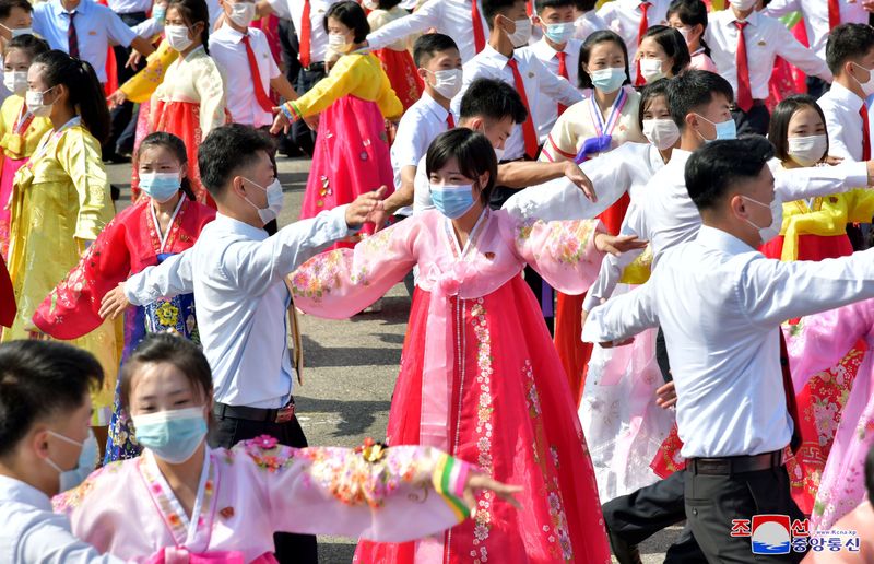 Students wearing face masks participate in a prom