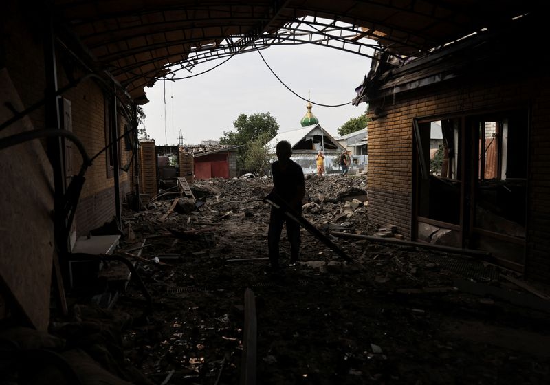 Neighbours collects debris of destroyed houses, after military strikes in Kramatorsk
