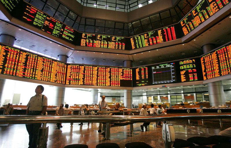 FILE PHOTO: Investors monitor stock market prices in Kuala Lumpur