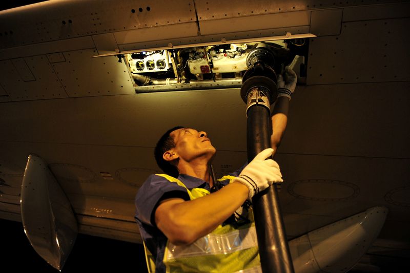 FILE PHOTO: Worker refuels a Dalian Airlines aircraft with aviation fuel at an airport in Hohhot