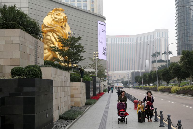 FILE PHOTO: Women and their children walk past the MGM Grand Macau resort in Macau