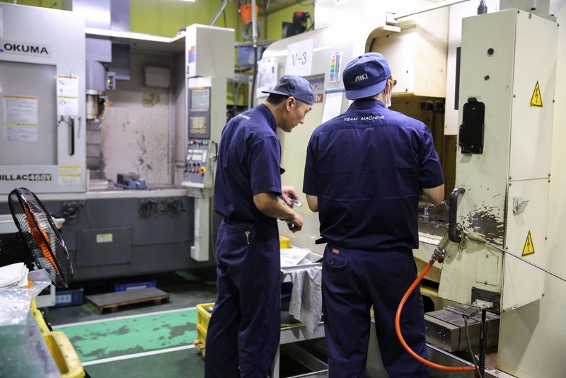 FOTO DE ARCHIVO: Trabajadores comprueban la maquinaria en una instalación del fabricante de componentes para aviones Aoki en Higashiosaka