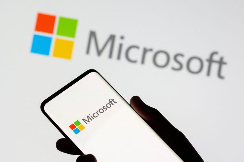 Un smartphone est vu devant le logo de Microsoft sur cette illustration