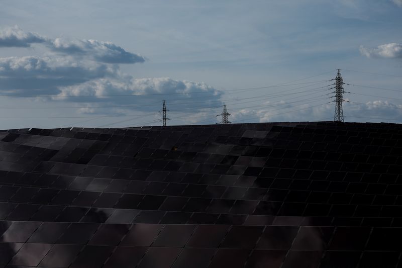 FOTO DE ARCHIVO: Líneas eléctricas de alta tensión y torres de alta tensión cerca de un conjunto de paneles solares de un parque de energía solar en Saelices