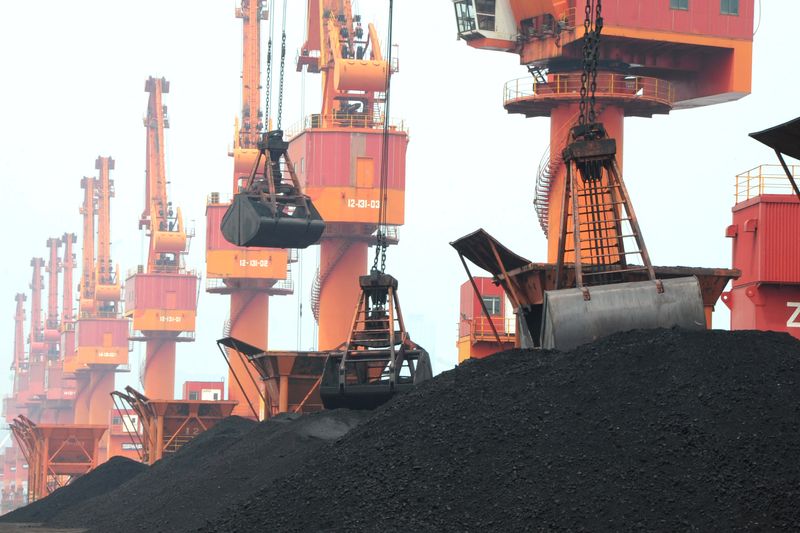 FILE PHOTO: Imported coal is seen lifted by cranes from a coal cargo ship at a port in Lianyungang, Jiangsu