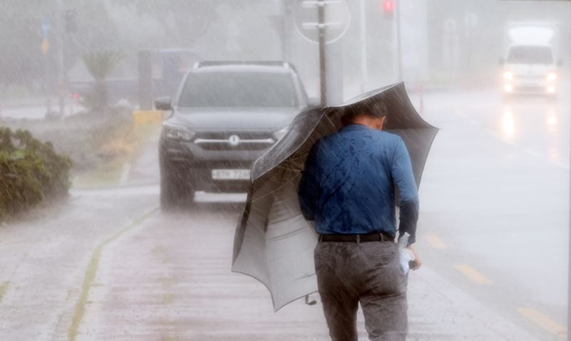 A man makes his way through strong wind caused by typhoon Hinnamnor on Jeju island