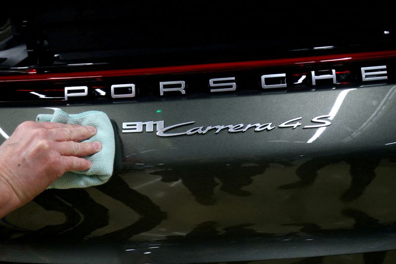 FOTO DE ARCHIVO: Un empleado del fabricante de automóviles alemán Porsche arregla una etiqueta de Porsche 911 Carrera 4S en la fábrica de Porsche en Stuttgart-Zuffenhausen, Alemania