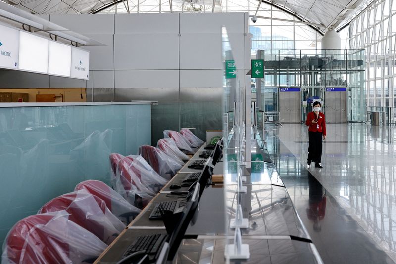 FILE PHOTO: A crew member of Cathay Pacific walks at the Hong Kong International Airport Departure Hall, amid the coronavirus disease (COVID-19) pandemic, in Hong Kong