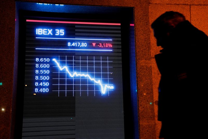 FOTO DE ARCHIVO. Un hombre pasa por delante de un cartel electrónico que muestra el índice bursátil español IBEX 35 en Madrid, España