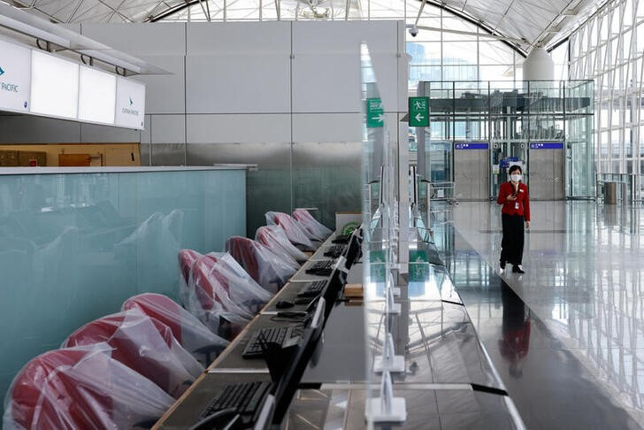 Imagen de archivo de una tripulante de Cathay Pacific hablando por la terminal de salidas del Aeropuerto Internacional de Hong Kong durante la pandemia del coronavirus.