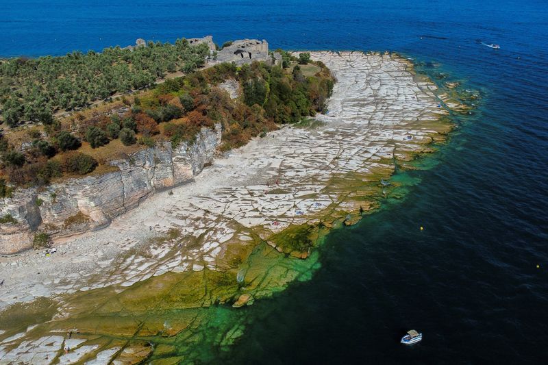 Una spiaggia rocciosa emerge dal lago di Garda dopo una grave siccità