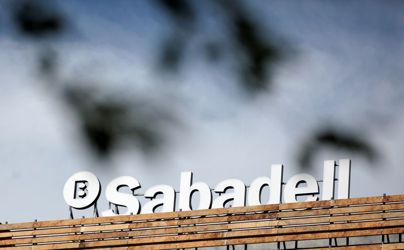 FILE PHOTO: The Banco Sabadell logo can be seen behind leaves on top of a building outside Madrid, Spain