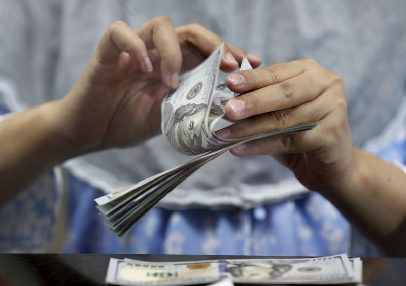 FILE PHOTO: A teller counts U.S. dollars at a money changer in Jakarta, Indonesia