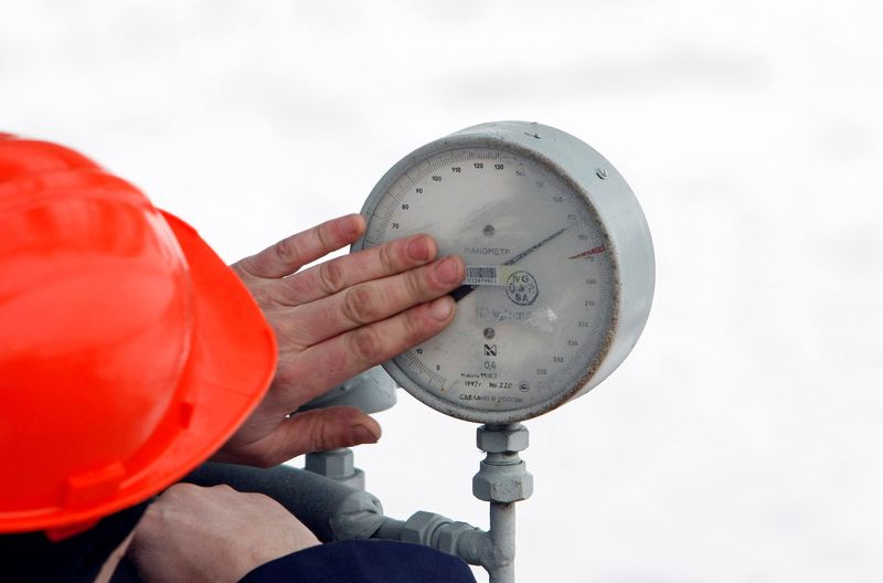 FILE PHOTO: A Gazprom technician inspects a pressure gauge at the gas export monopoly's Sudzha compressor station