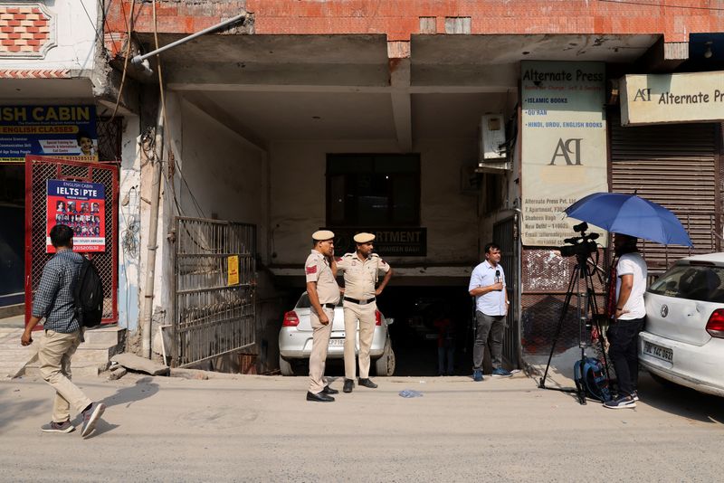 Media and policemen stand outside the office of Popular Front of India (PFI) Islamic group, in New Delhi