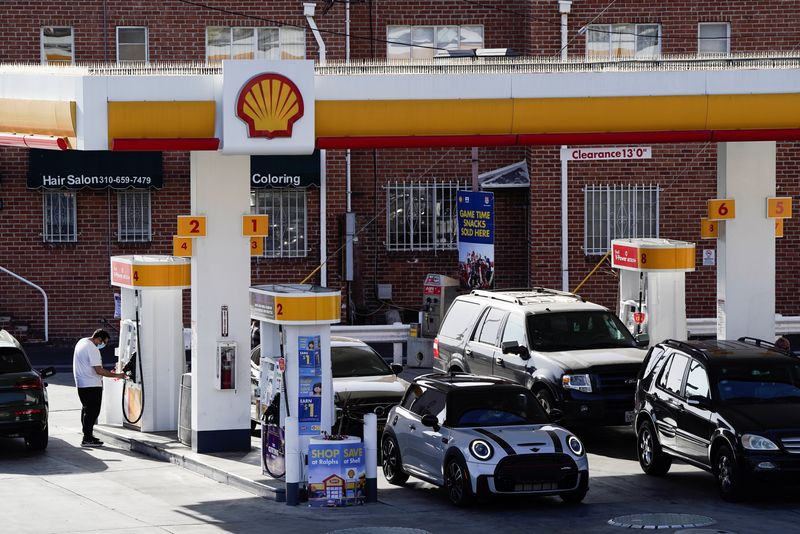 People refuel their vehicles with gasoline at a Shell gas station in Los Angeles