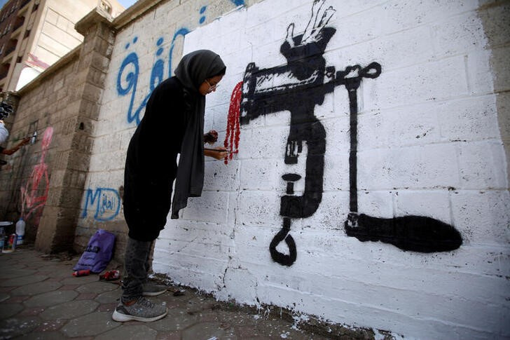FILE PHOTO: An artist paints a mural as part of the 