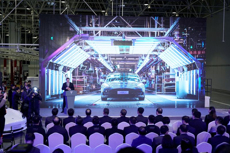 FILE PHOTO: Tesla Inc CEO Elon Musk speaks next to a screen showing an image of Tesla Model 3 car during an opening ceremony for Tesla China-made Model Y program in Shanghai