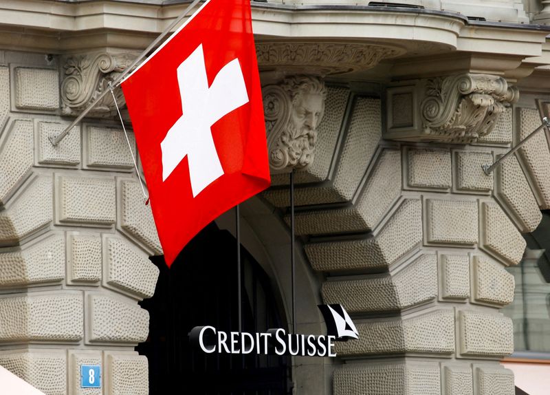 Le drapeau national suisse flotte au-dessus du logo de la banque suisse Credit Suisse à Zurich