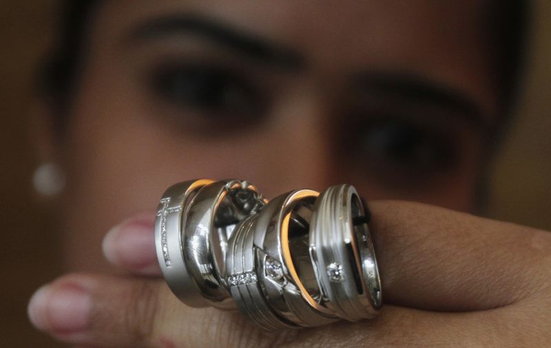 FILE PHOTO: A saleswoman displays platinum rings for the camera at a jewellery showroom in New Delhi