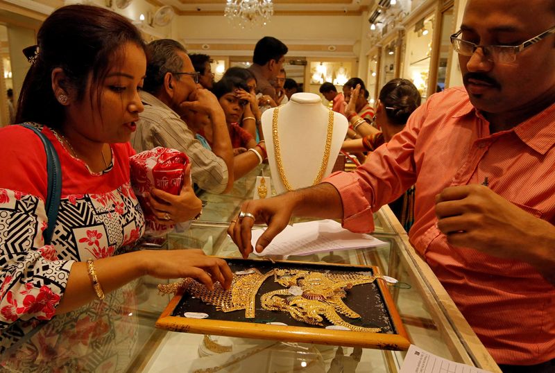 FILE PHOTO: A salesman shows gold necklaces to a customer at a jewellery showroom during Dhanteras, a Hindu festival associated with Lakshmi, the goddess of wealth, in Kolkata