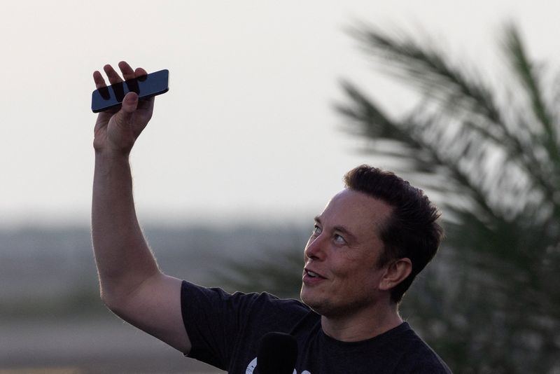 FILE PHOTO: Musk raises phone towards the sky at SpaceX Starbase in Brownsville, Texas