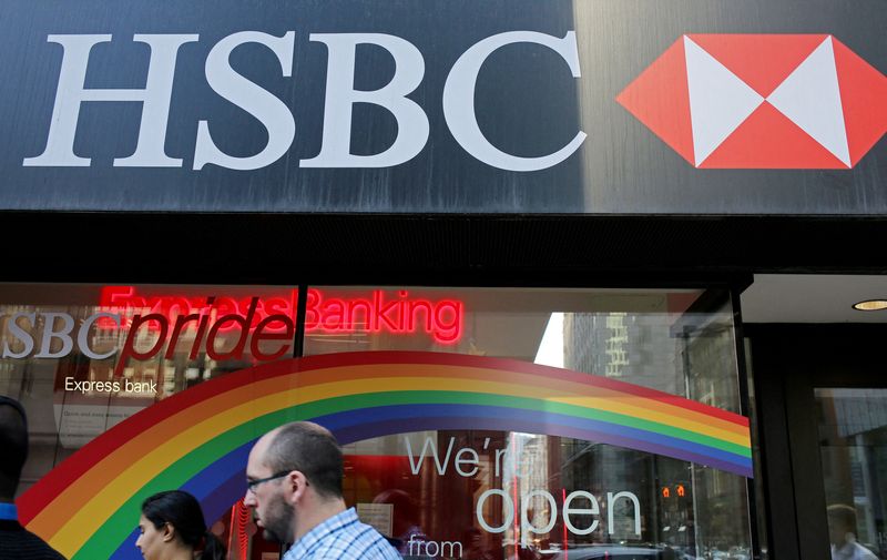 FILE PHOTO: People pass by a branch of HSBC bank adorned with colours of the Pride rainbow flag, in downtown Toronto