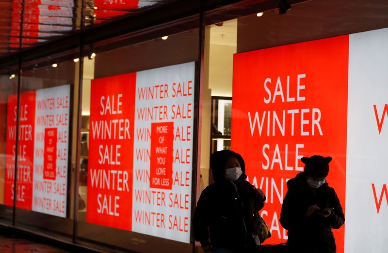 FILE PHOTO: People queue outside a John Lewis a store announcing a seasonal sale, in London