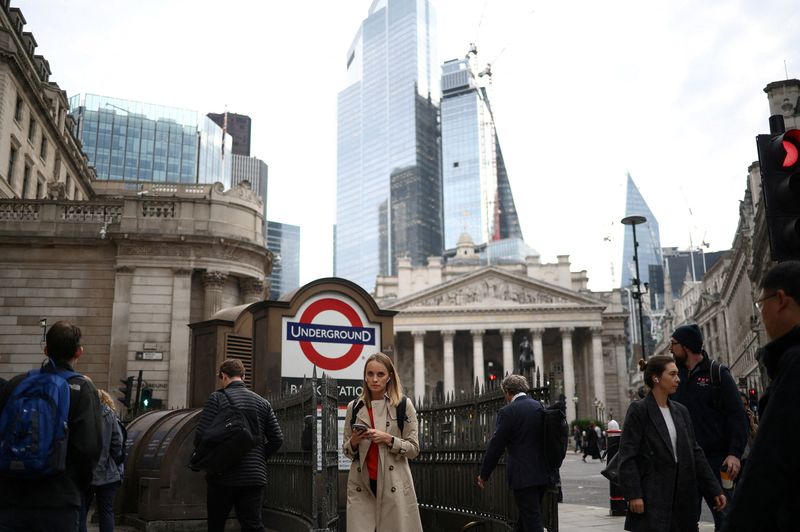 FILE PHOTO: People exit Bank underground station in the City of London financial district during rush hour in London