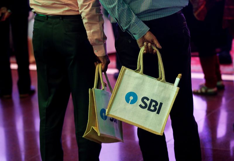 The State Bank of India (SBI) logo is seen on bags carried by participants during a news conference in Mumbai