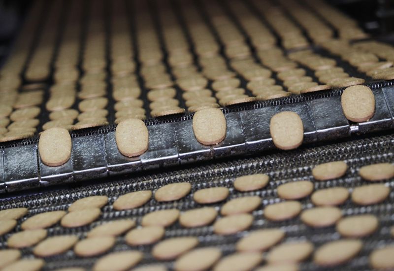 Biscuits pass along a conveyor belt after being baked at the Britannia factory in New Delhi