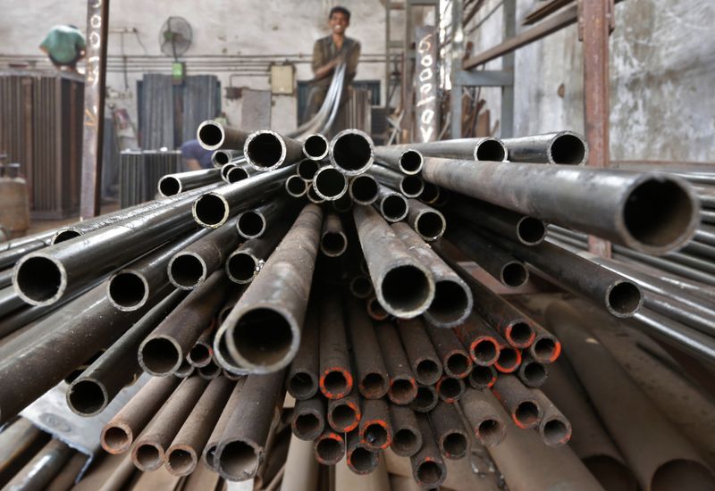 A worker stacks steel pipes in the western Indian city of Ahmedabad