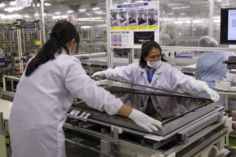 FILE PHOTO: Women assemble an Aquos television at Sharp Corp's Tochigi plant in Yaita