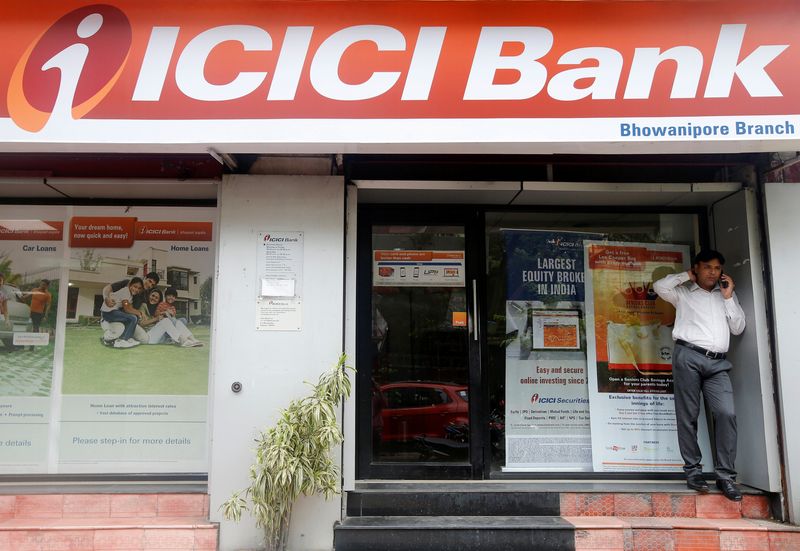 A man speaks on the phone outside an ICICI Bank branch in Kolkata