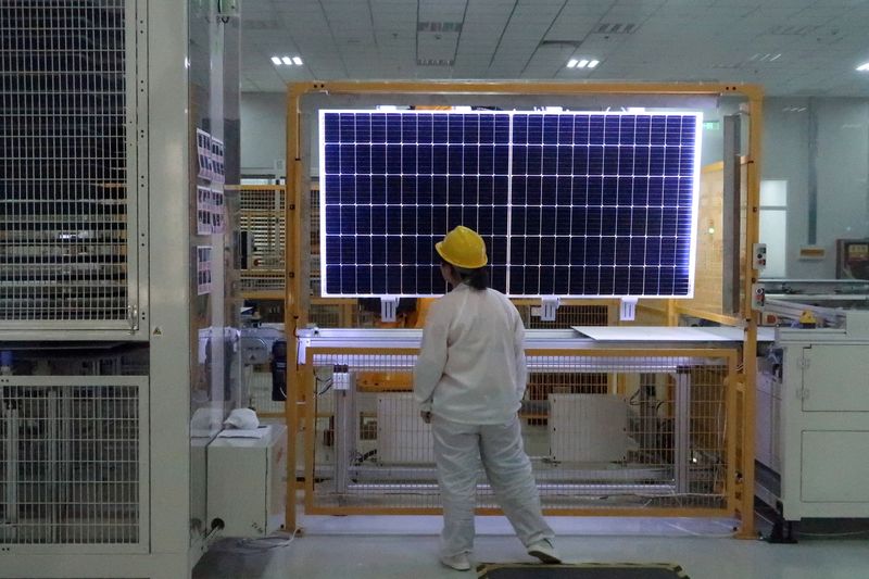 FILE PHOTO: Worker conducts quality-check of a solar module product at a factory of a monocrystalline silicon solar equipment manufacturer in Xian, Shaanxi