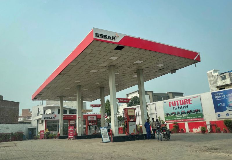 A man pays after buying petrol at an Essar fuel station in Lucknow