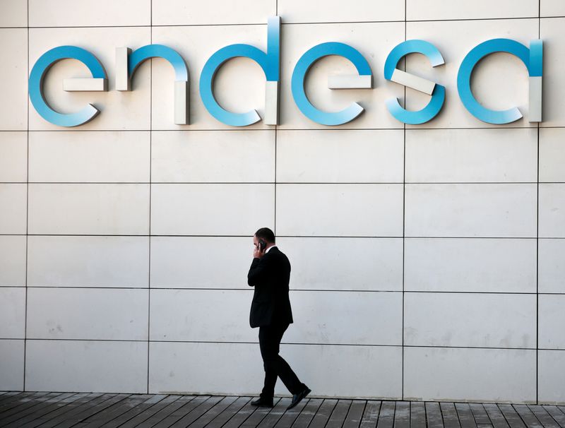 Un uomo cammina sotto il logo della società elettrica spagnola Endesa nella sua sede centrale di Madrid, in Spagna.