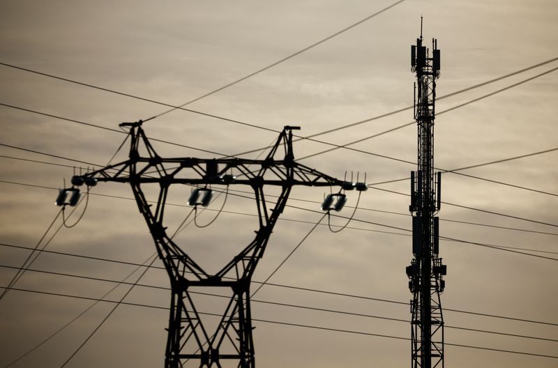 FILE PHOTO: A mobile-phone relay mast is seen behind an electrical pylon in Reze