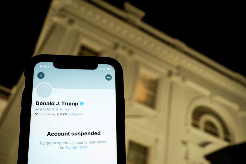 FILE PHOTO: : A photo illustration shows the suspended Twitter account of U.S. President Donald Trump on a smartphone and a lit window in the White House residence in Washington