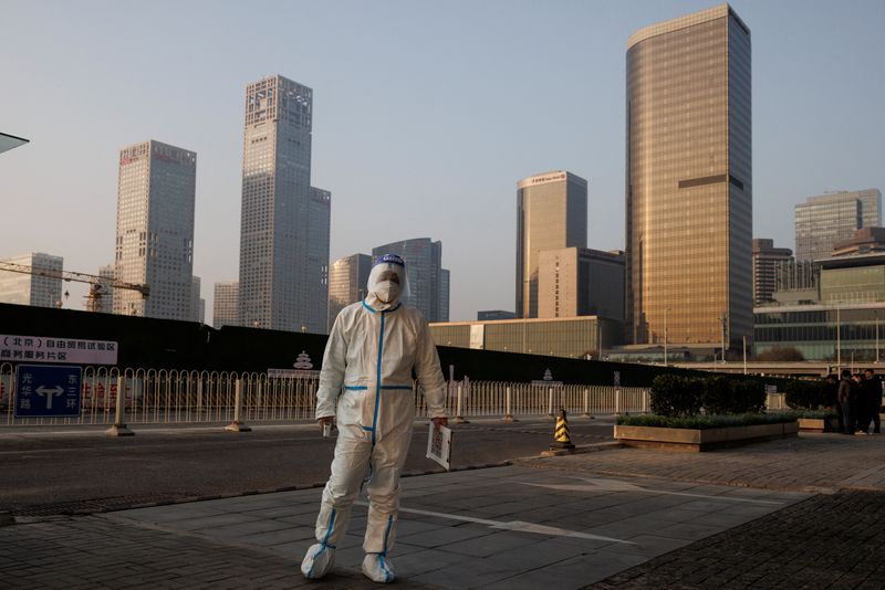 An epidemic prevention worker in a protective suit guards the entrance to an office building in the Central Business District (CBD) as outbreaks of the coronavirus disease (COVID-19) continue in Beijing