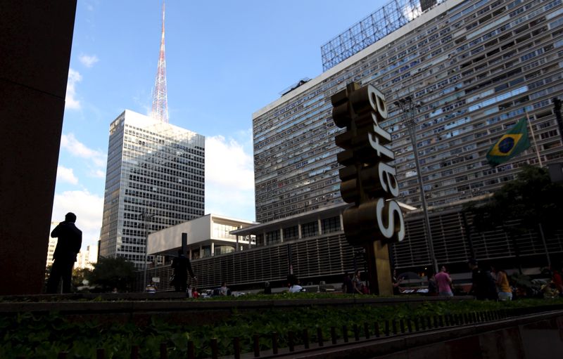 FILE PHOTO: A man talks on his mobile phone next to the  Banco Safra SA headquarter in Sao Paulo
