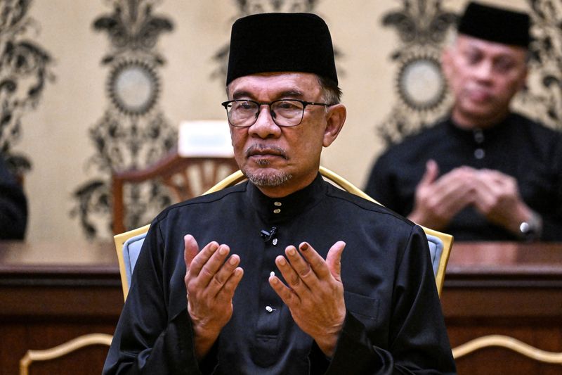 Malaysia's newly appointed PM Ibrahim offers prayers after taking the oath during the swearing-in ceremony at the National Palace in Kuala Lumpur