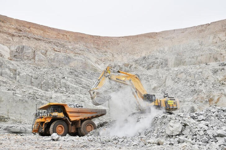 FILE PHOTO: FILE PHOTO: An excavator driven by Rosalie Guirou Kulga, 30, clears out rocks into a dumper at the gold mine, operated by Endeavour Mining Corporation in Hounde
